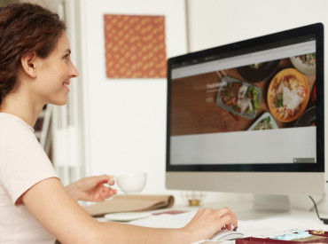 Femme devant un site web de restaurant