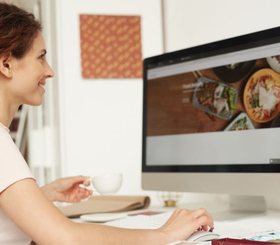 Femme devant un site web de restaurant