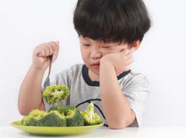 Enfant devant une assiette de légumes