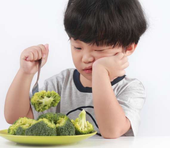 Enfant devant une assiette de légumes