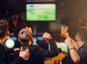 3 hommes regardant un match dans un bar