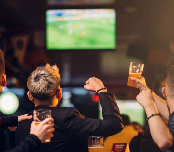 3 hommes regardant un match dans un bar