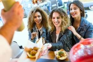 trois-belles-jeunes-femmes-visitent-manger-du-marche-dans-la-rue_1301-5696