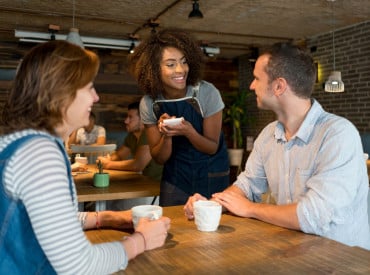 Deux clients se faisant servir par une serveuse