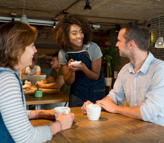 Deux clients se faisant servir par une serveuse