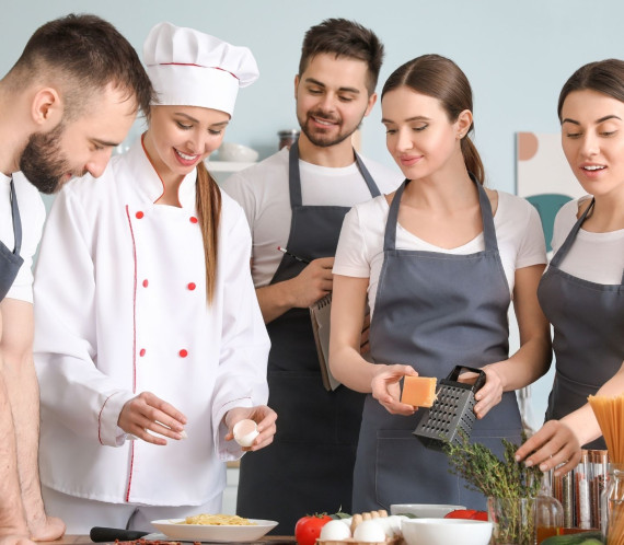 Personnes durant un cours de cuisine dispensé par un chef