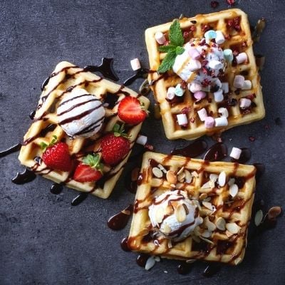 Trois gaufres avec fruits, chocolat et bonbons 