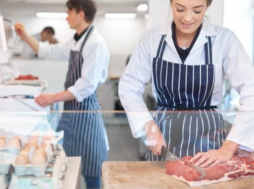 Bouchère découpant de la viande